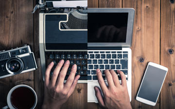 Half typewriter and old camera and other half laptop and smartphone